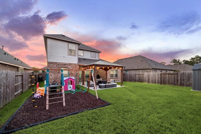 rear view of house featuring a patio area, brick siding, a lawn, and a fenced backyard