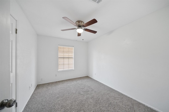 carpeted spare room featuring a ceiling fan and baseboards