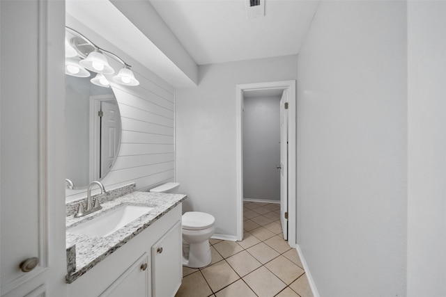 bathroom featuring visible vents, toilet, vanity, tile patterned flooring, and baseboards