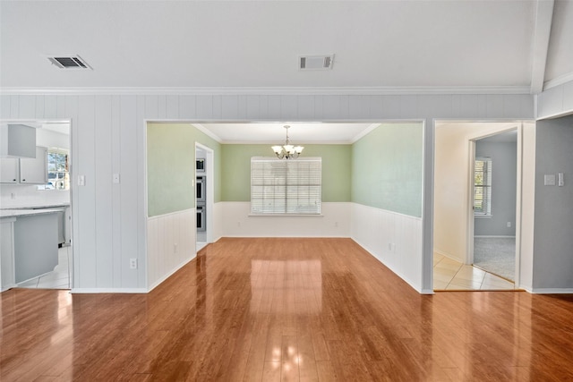 interior space featuring a healthy amount of sunlight, visible vents, and an inviting chandelier