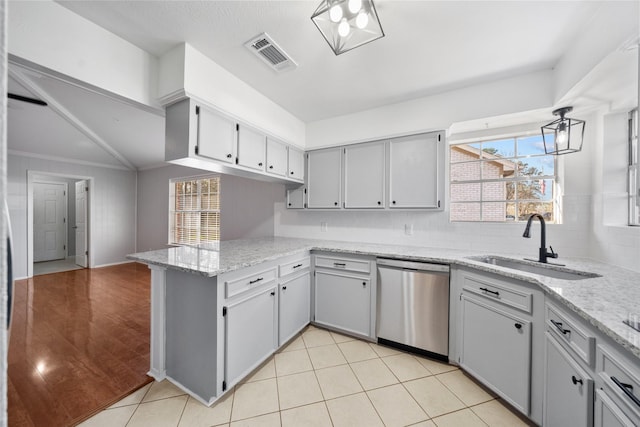 kitchen with visible vents, dishwasher, a peninsula, a sink, and light tile patterned flooring