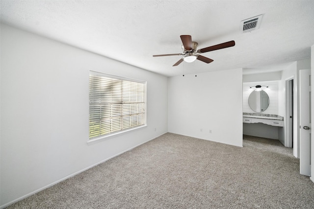 unfurnished bedroom with ceiling fan, visible vents, a textured ceiling, and light colored carpet