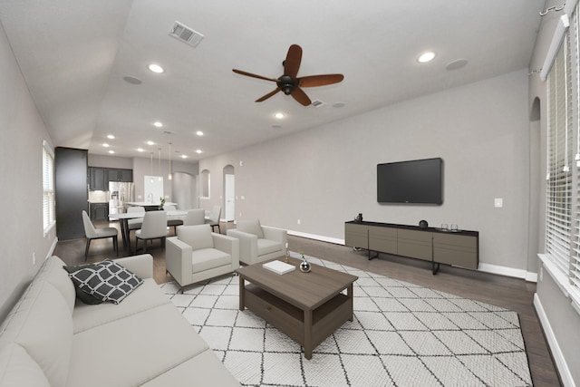 living room featuring light wood finished floors, visible vents, arched walkways, and recessed lighting