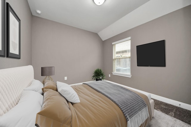 bedroom featuring carpet floors, baseboards, and vaulted ceiling