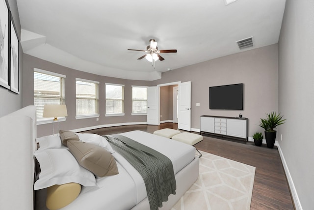 bedroom featuring baseboards, visible vents, ceiling fan, and wood finished floors