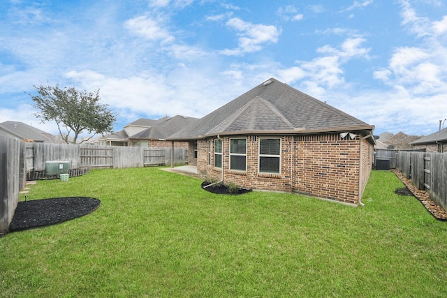 rear view of house with roof with shingles, brick siding, and a lawn