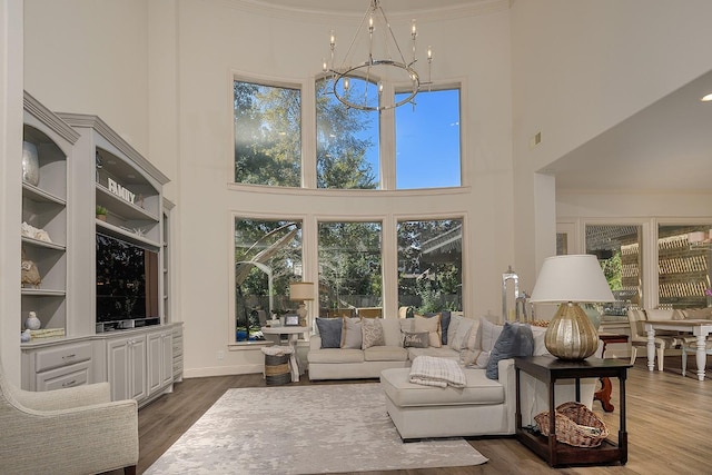 living area featuring a chandelier, plenty of natural light, and wood finished floors