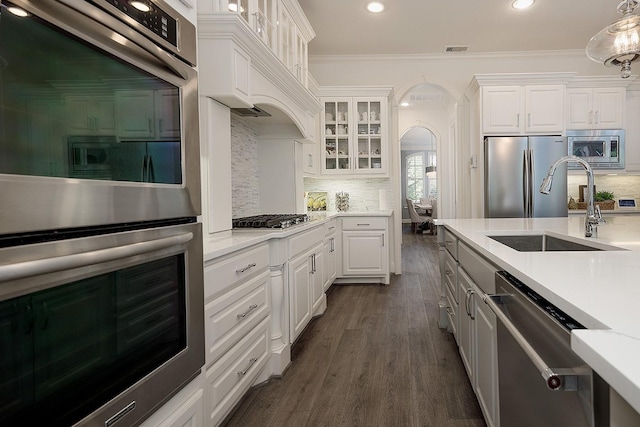 kitchen featuring light countertops, appliances with stainless steel finishes, a sink, and white cabinets