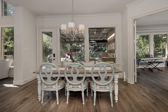 dining area featuring dark wood-style floors, ornamental molding, an inviting chandelier, and a healthy amount of sunlight