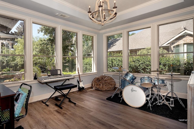 sunroom with a raised ceiling, visible vents, and an inviting chandelier