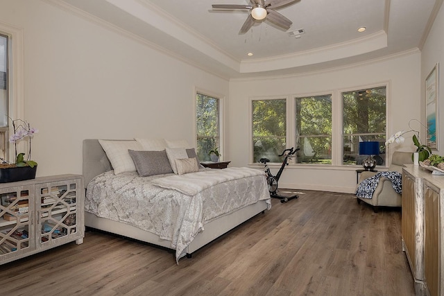 bedroom featuring ornamental molding, a raised ceiling, visible vents, and wood finished floors