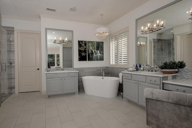 full bathroom featuring ornamental molding, a stall shower, visible vents, and a sink