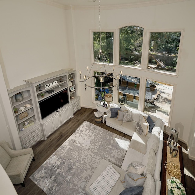 living area with ornamental molding, dark wood-style flooring, and baseboards