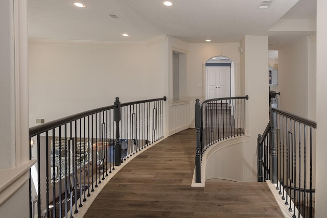 corridor with recessed lighting, wood finished floors, an upstairs landing, baseboards, and crown molding