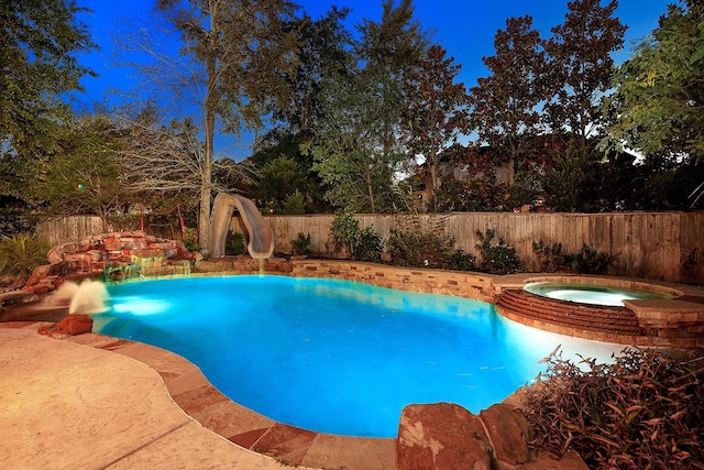 view of swimming pool featuring a fenced in pool, a water slide, a fenced backyard, and an in ground hot tub