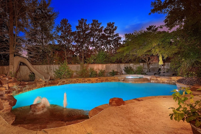 view of swimming pool with a fenced in pool, a water slide, a fenced backyard, and an in ground hot tub