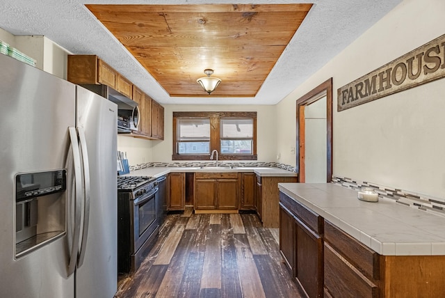 kitchen with brown cabinets, appliances with stainless steel finishes, wooden ceiling, a raised ceiling, and dark wood-style flooring