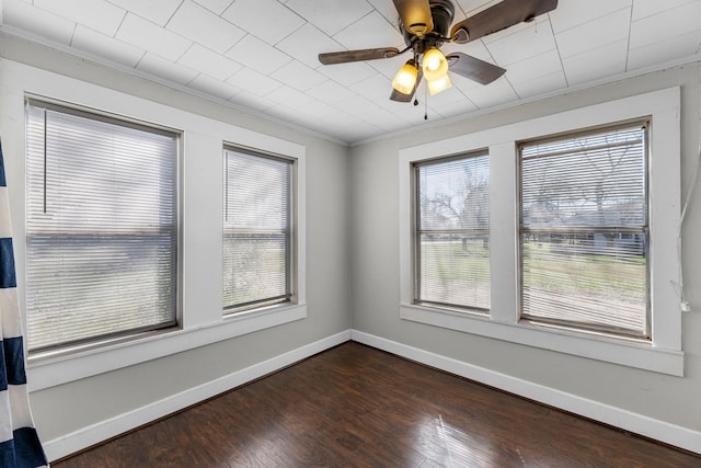 unfurnished room featuring dark wood-style floors, a healthy amount of sunlight, and baseboards