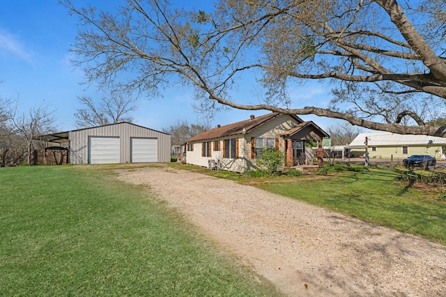 view of front facade featuring a front yard, an outbuilding, a detached garage, and dirt driveway