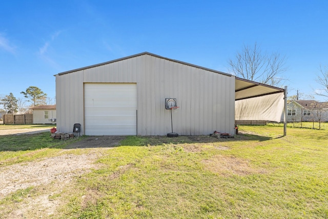 detached garage with a carport and driveway