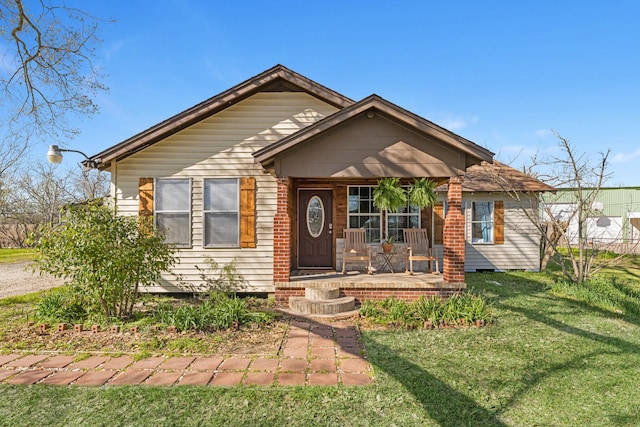 view of front of home featuring covered porch and a front lawn