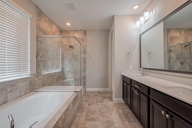 bathroom featuring a garden tub, double vanity, a stall shower, and a sink