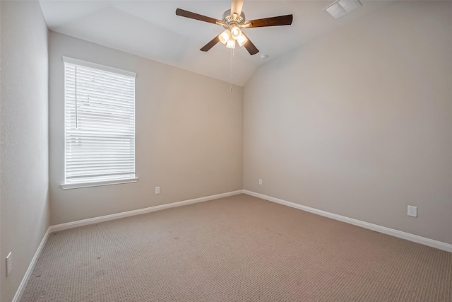 carpeted empty room featuring lofted ceiling, ceiling fan, visible vents, and baseboards