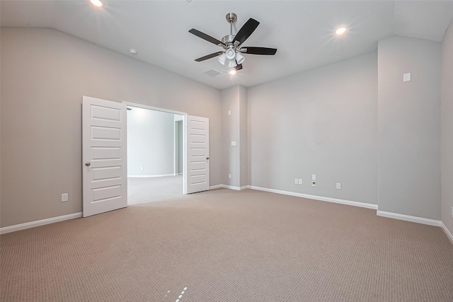 empty room with vaulted ceiling, light carpet, and baseboards