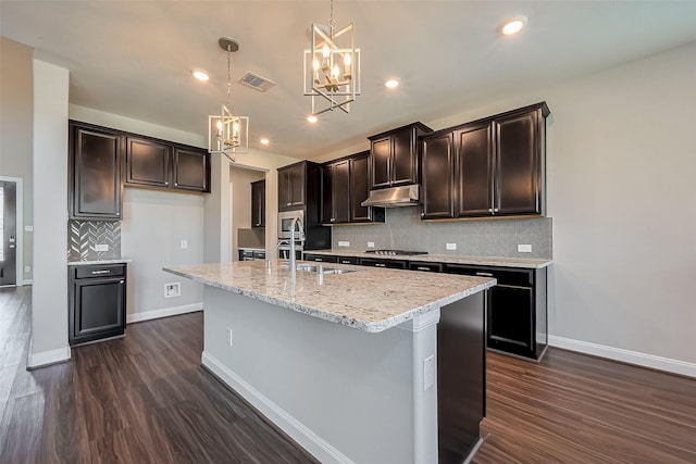 kitchen featuring dark wood finished floors, visible vents, appliances with stainless steel finishes, a sink, and under cabinet range hood