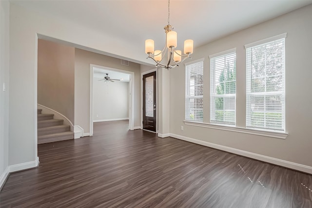 unfurnished dining area featuring ceiling fan with notable chandelier, dark wood-style flooring, visible vents, baseboards, and stairway