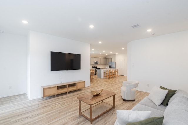 living room featuring recessed lighting, visible vents, light wood finished floors, and baseboards