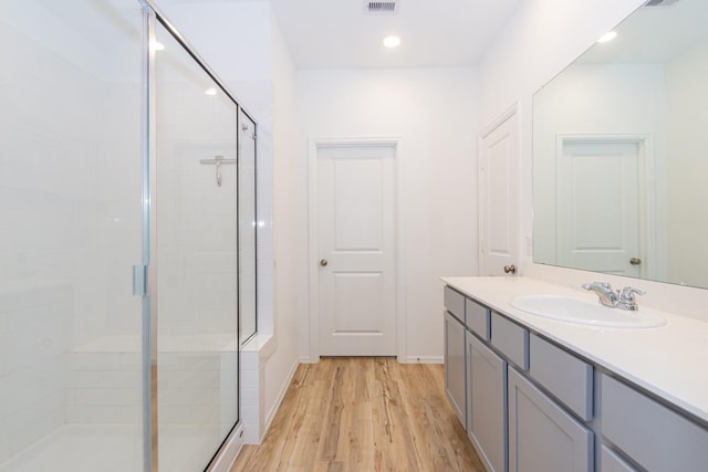 full bath with vanity, wood finished floors, visible vents, recessed lighting, and a shower stall