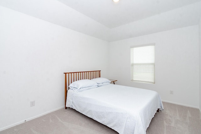 bedroom featuring baseboards and light carpet