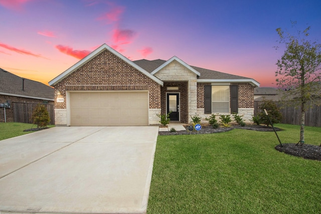 view of front of property featuring stone siding, a yard, concrete driveway, an attached garage, and brick siding