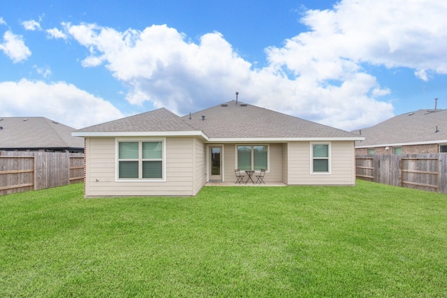 back of house with a lawn, a patio, a fenced backyard, and roof with shingles