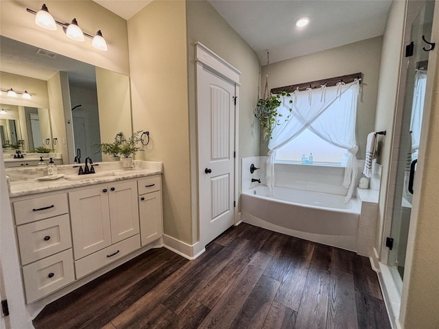 full bath featuring a garden tub, wood finished floors, vanity, baseboards, and a shower stall