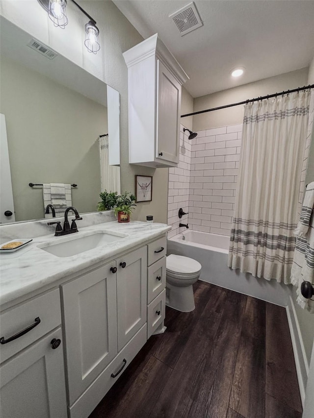 bathroom featuring shower / bath combo, visible vents, wood finished floors, and vanity