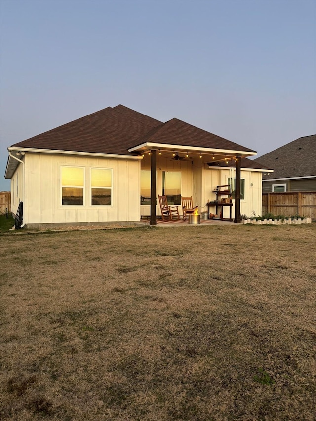 back of house featuring ceiling fan, fence, a yard, a patio area, and board and batten siding