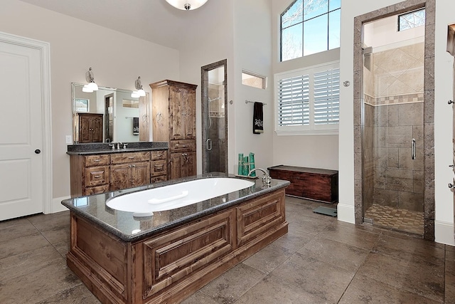 full bath featuring baseboards, a garden tub, a stall shower, and vanity