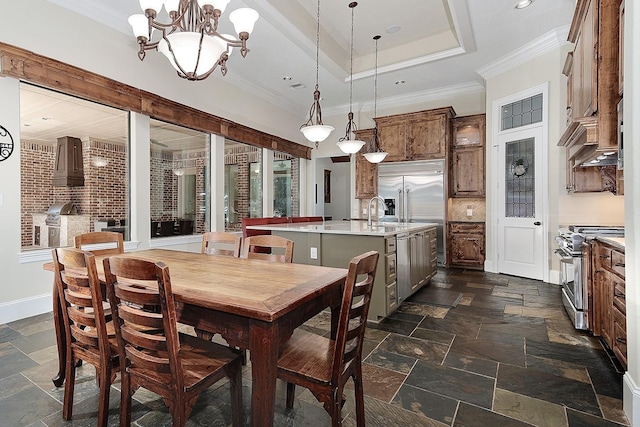 dining space featuring a raised ceiling, a notable chandelier, stone tile floors, crown molding, and baseboards