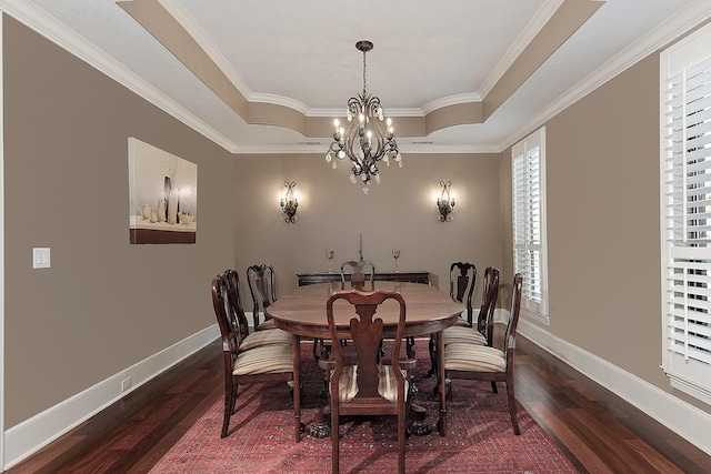 dining space featuring dark wood finished floors, an inviting chandelier, a raised ceiling, and baseboards