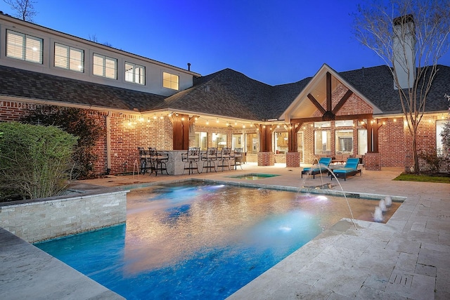 pool with a patio area, an in ground hot tub, and outdoor dry bar