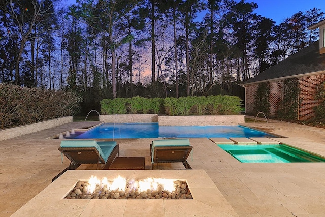 outdoor pool with a patio area and an outdoor fire pit