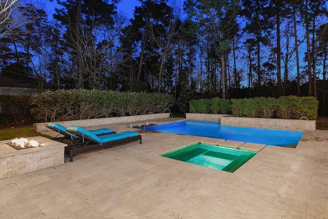 outdoor pool featuring an outdoor fire pit, an in ground hot tub, and a patio area