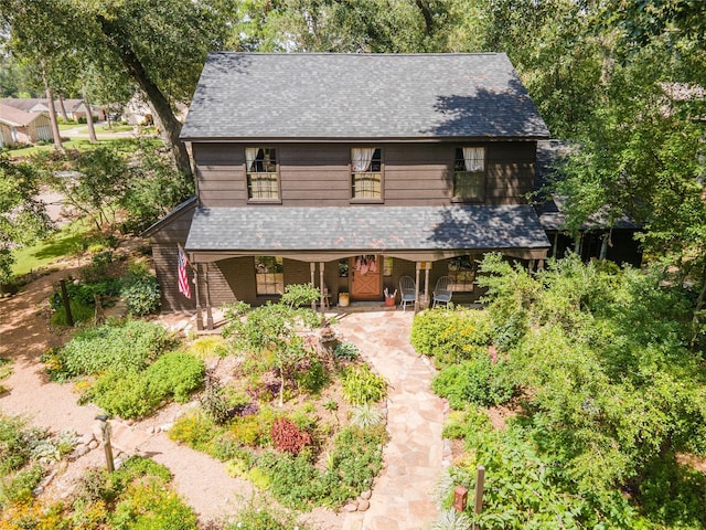rustic home featuring a porch and a shingled roof