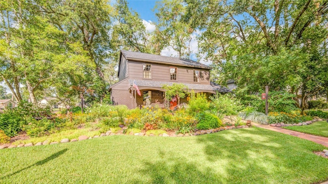 view of front of property with a front lawn and brick siding