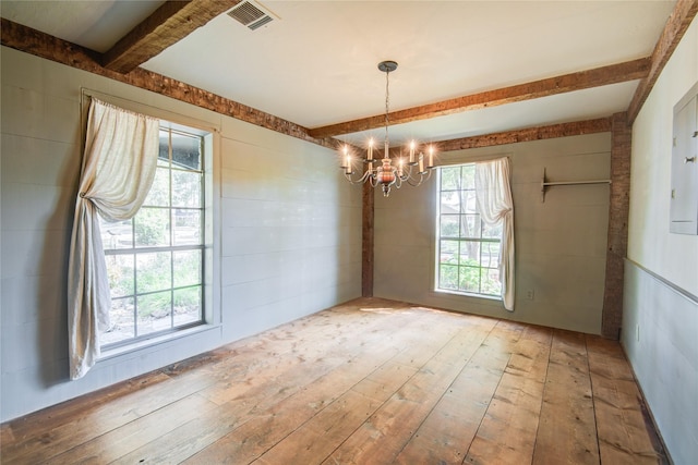 unfurnished dining area with beam ceiling, visible vents, a notable chandelier, and hardwood / wood-style flooring