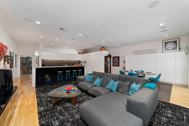 living area with recessed lighting, visible vents, and light wood-style flooring