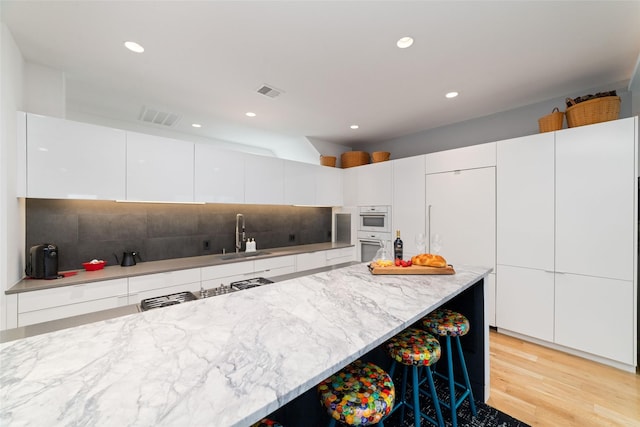 kitchen with modern cabinets, a sink, and visible vents