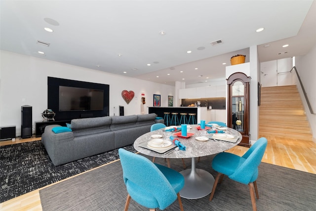 dining space featuring visible vents, stairway, wood finished floors, and recessed lighting